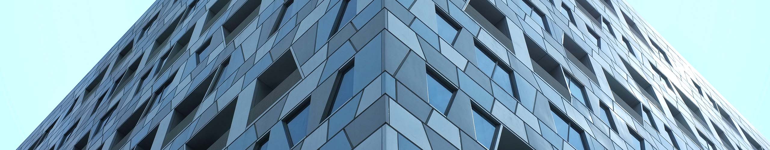 A background banner looking up at a modern, structurally interesting building with many windows.